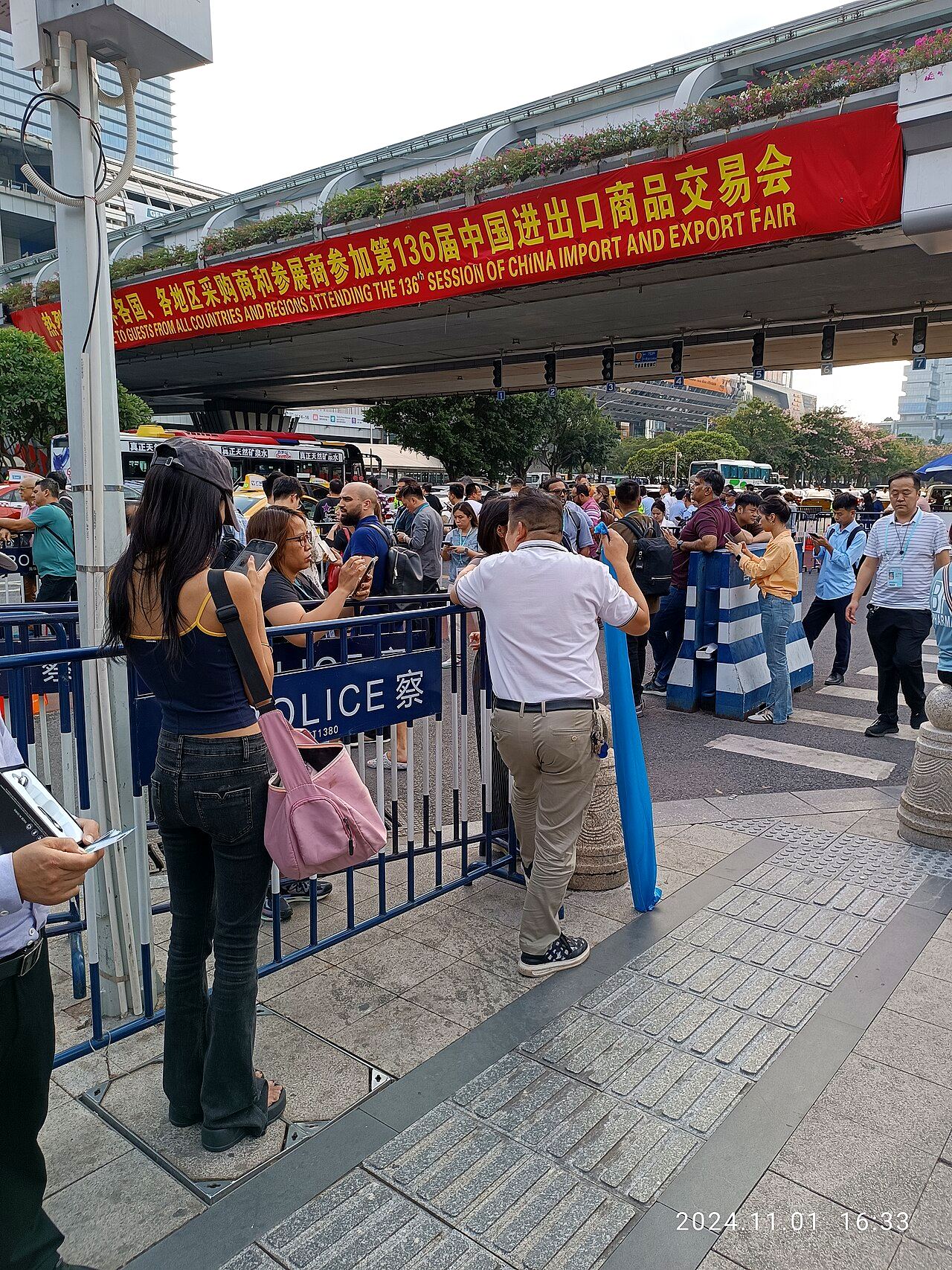 Visitantes à entrada da Canton Fair sob a faixa vermelha de boas-vindas